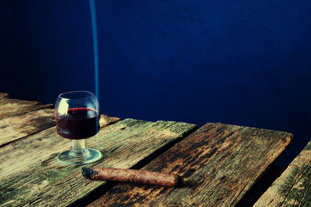 Cigar and wine on old wooden background.の写真素材