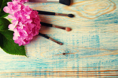 Makeup brushes and hydrangea on the abstract wooden blue background.の写真素材