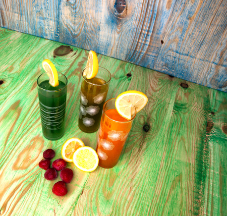 Fresh healthy fruit juices on a wooden abstract backgroundの写真素材