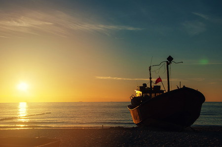 Fishing boats on the beach at sunset.