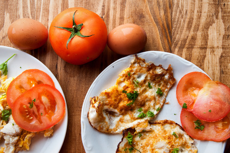 scrambled, fried, boiled eggs on a wooden table.の写真素材