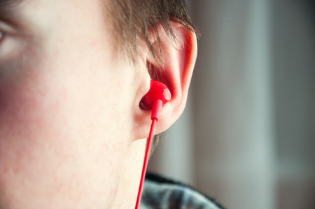 Close up of red headphone in mans ear.の写真素材