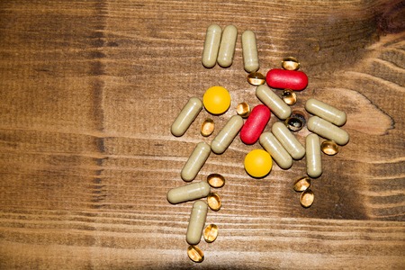 concept of supplements, pills on a wooden table.