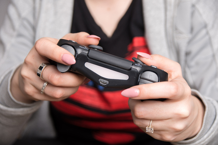 an image of a girl holding a black gaming pad.の写真素材