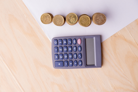 stacks of money and a calculator on a wooden background.の写真素材