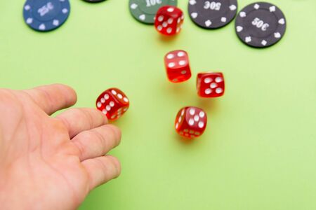 man throwing dice. Poker chips. Green background