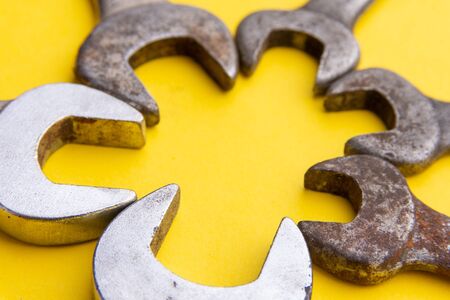 Old and new wrenches on a yellow backgroundの写真素材
