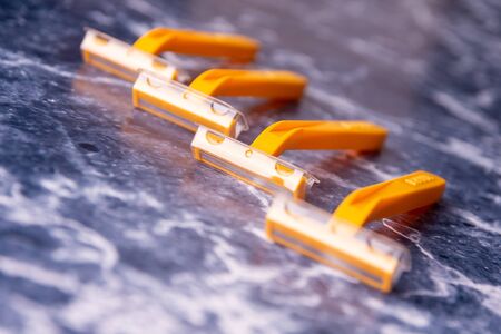 Four yellow razors on a blue background