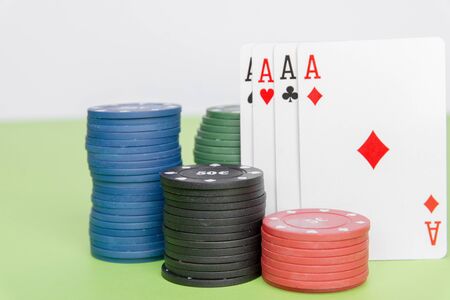 poker chips stack with two cards an ACE. On the green table on a black, dark background.の写真素材