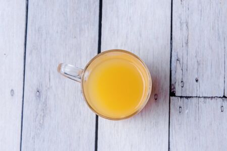 Half cup of orange juice on a white wooden background.の写真素材