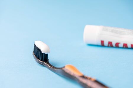 Toothpaste on a toothbrush close-up on a blue light background