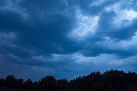 Creepy rainy clouds over a dark forest.の写真素材