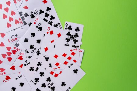 Playing cards on a green background. From above. Place for text.