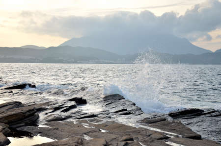 Big waves and huge water splash on rocky coast and seashoreの写真素材