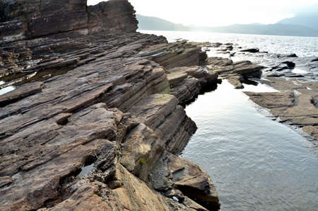 Rock in the Bay of Island under sunriseの写真素材
