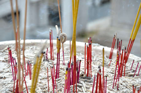 Burning yellow stick in joss stick pot in templeの写真素材