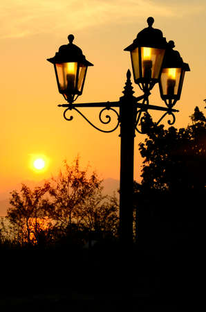 The antique street lamp pillar under the beautiful sunsetの写真素材