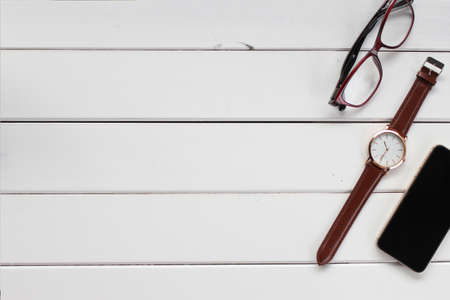 Free space. copy space white wooden table with smartphone, watch and glassesの写真素材