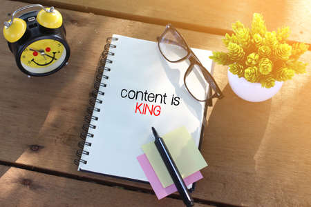 Content is king concept with notebook on wooden table
