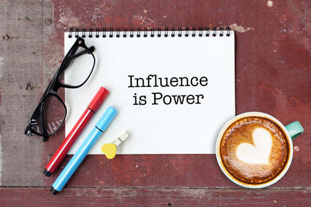 Influence is Power writing on notebook with coffee