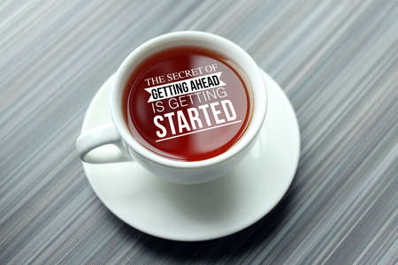 Inspirational success quotes on top view of coffee cup on wooden table. The secret of getting ahead...