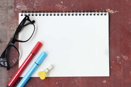 Design concept - Top view of orange and red spiral notebook and color pencil collection isolated on...