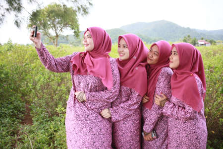 KANGAR,PERLIS,MALAYSIA. 10th April 2019: Bride with beautiful bridesmaids in pink dresses holding bouquets. Autumn in the Park.のeditorial素材