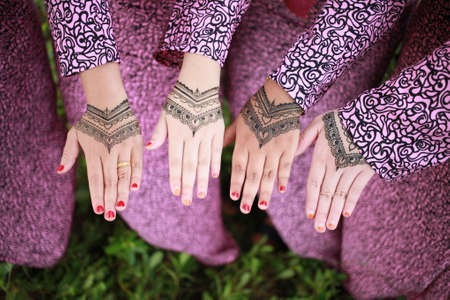 Woman Hands with black mehndi tattoo. Hands of Indian bride girl with black henna tattoos. Hand with perfect turquoise manicure and national Indian jewels. Fashion. India. Marriage traditionsの写真素材