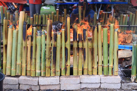 Making (Lemang) glutinous rice in bamboo cooked using firewood is a traditional way of the Malays. Lemang usually eaten with Rendang on festive day.の写真素材