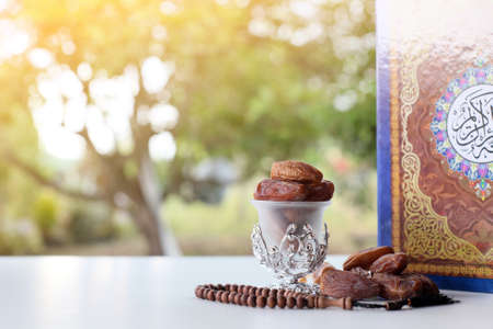 Ramadan kareem with dates, rosary and holy quran on fresh green backgroundの写真素材