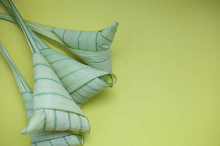 Top view ketupat or rice dumpling icon of the hari raya.yellow background and copy spaceの写真素材