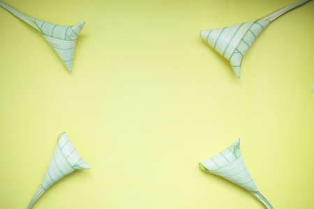 Top view ketupat or rice dumpling icon of the hari raya.yellow background and copy spaceの写真素材