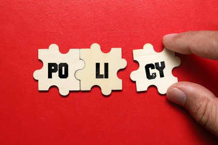 Puzzle pieces with word POLICY on red background, closeupの写真素材
