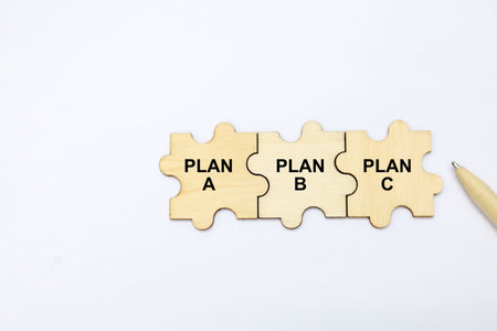 Plan Plan B text on wooden puzzle pieces isolated on white background.の写真素材