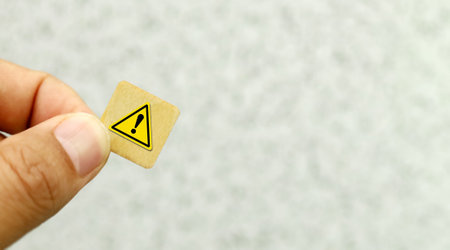 Wooden block with exclamation mark on the wall background. Safety concept