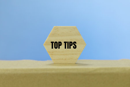 top tips text on wooden hexagon on brown paper box and blue backgroundの写真素材
