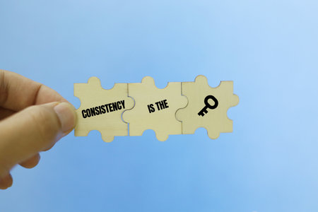 Jigsaw puzzle pieces with the word CONSISTENCY IS KEYの写真素材