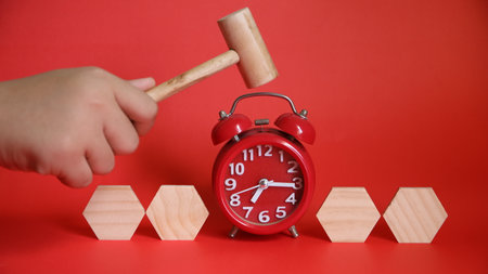 Alarm clock and wooden blocks on red background. Time management conceptの写真素材