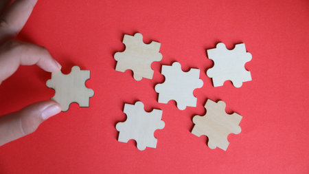 Wooden puzzle pieces on a red background. The concept of solving puzzles.の写真素材