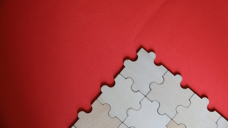 Close up of blank jigsaw puzzle on red background with copy spaceの写真素材