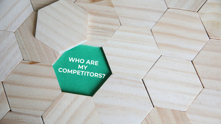 Wooden hexagon with the words who are my competitions?の写真素材