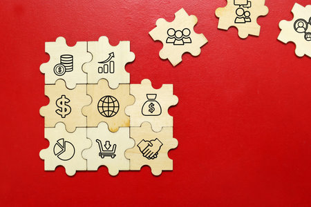 Jigsaw puzzle pieces with business icons on red background, business conceptの写真素材