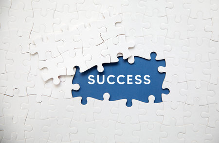 Missing piece of puzzle with word success. Business concept image for completing the puzzle.の写真素材
