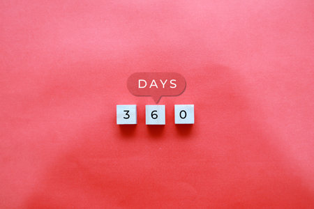 Three wooden blocks with the numbers 3, 6, and 0 on a red backgroundの写真素材