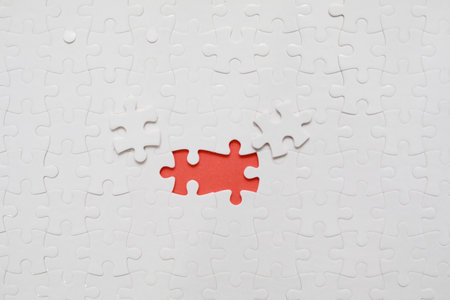 Top view of white jigsaw puzzle with missing pieceの写真素材