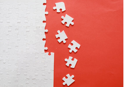 White jigsaw puzzle pieces on red and white background. Business conceptの写真素材