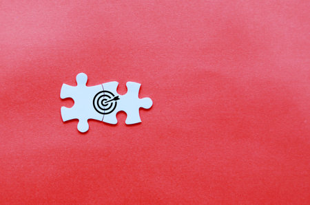 White puzzle with target on red background. Business concept. Top view.