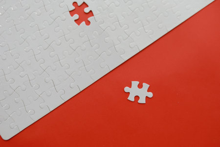 White jigsaw puzzle with missing piece on red background. Business concept.の写真素材