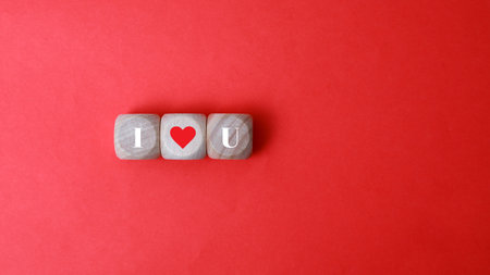 I love you. Wooden cubes with red heart on red background.の写真素材