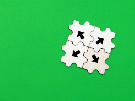 Puzzle pieces with arrows on green background. Copy space for textの写真素材